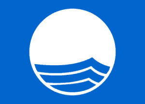 De Blauwe Vlag : teken van een schoon strand of een schone jachthaven. Het is een blauwe vlag met in het midden een witte cirkel met drie gegolfde blauwe lijnen, die de zee uitbeelden.